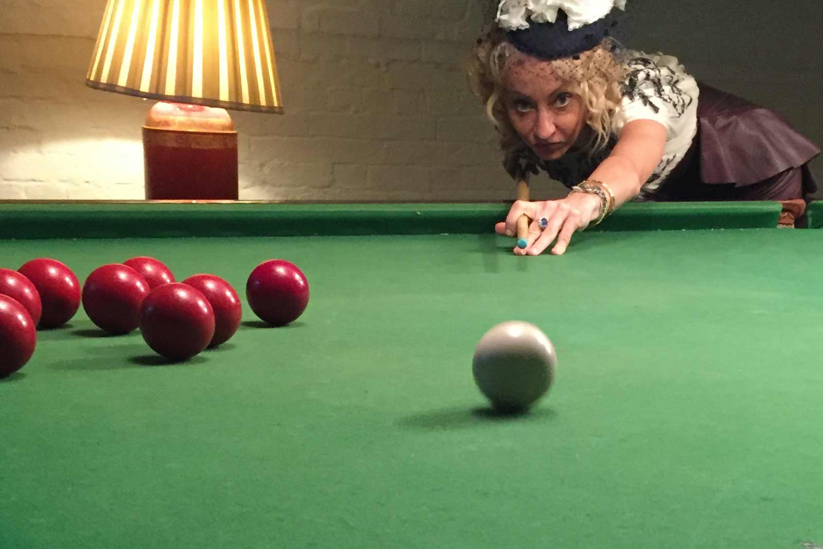 Anastasia playing pool in traditional Austrian dress